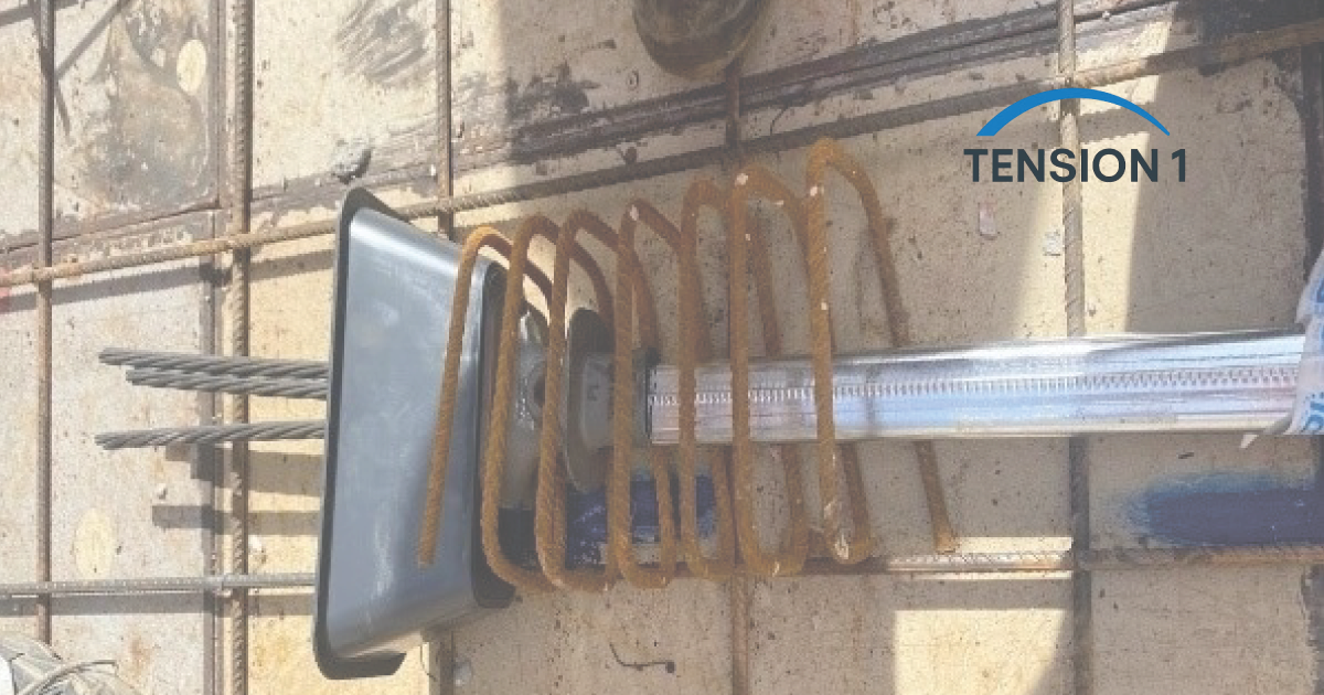 Close-up of a post tension slab anchorage assembly setup, showing high-strength steel tendons, a metal duct, and bursting reinforcement coils before concrete pouring.